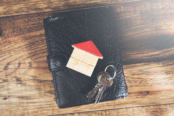 courtier rueil-malmaison avec clés et petite maison posées sur un portefeuille